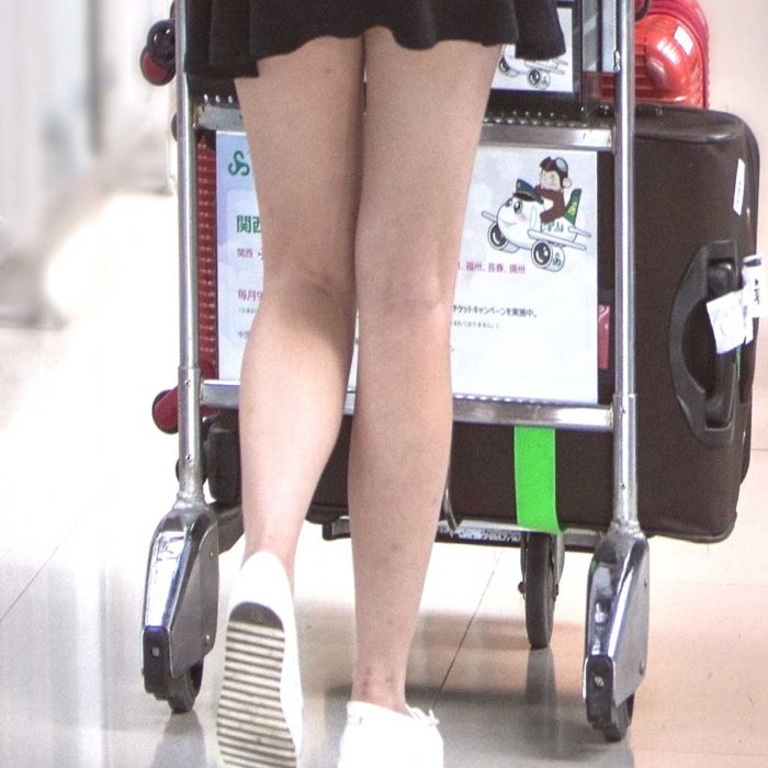空港でキャリーカートを押す女性